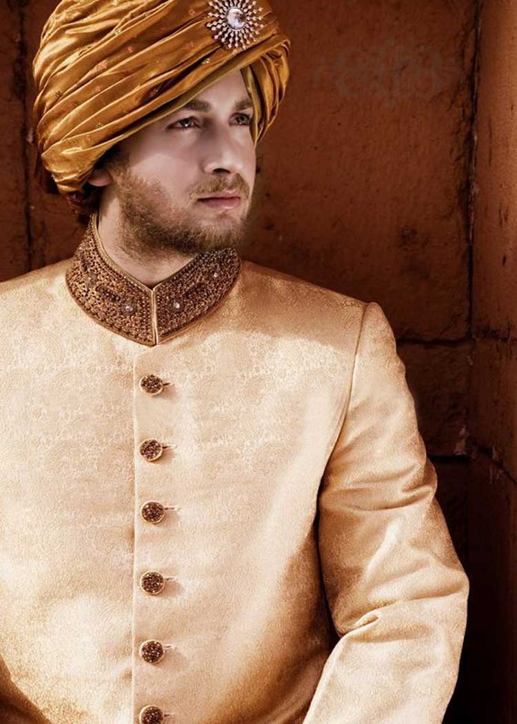 Indian groom in golden sherwani posing for picture. | Photo 260857